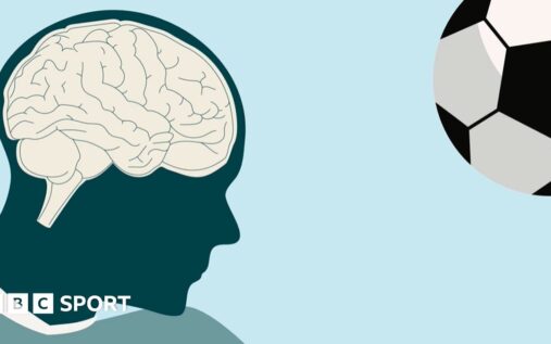 A modern football suspended in the air right before a player makes a header during a match