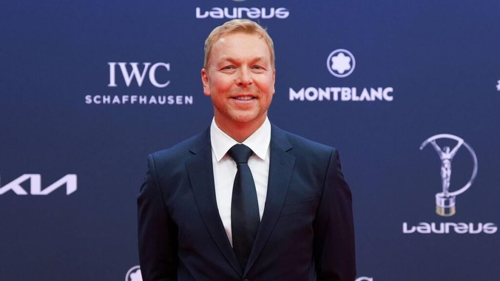 Sir Chris Hoy riding a bicycle outdoors with friends in the countryside