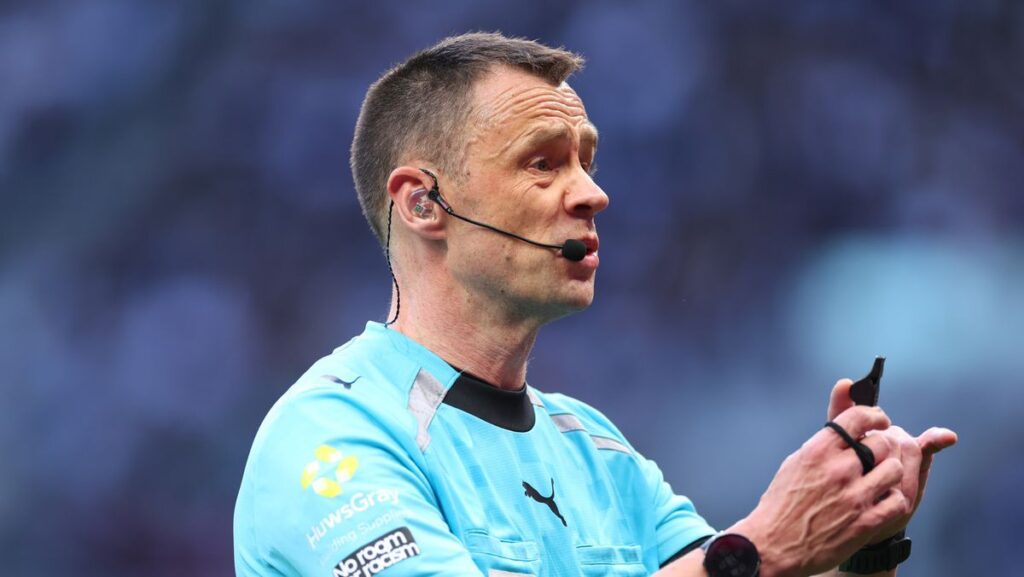 Premier League referee Stuart Attwell officiating a football match on the pitch