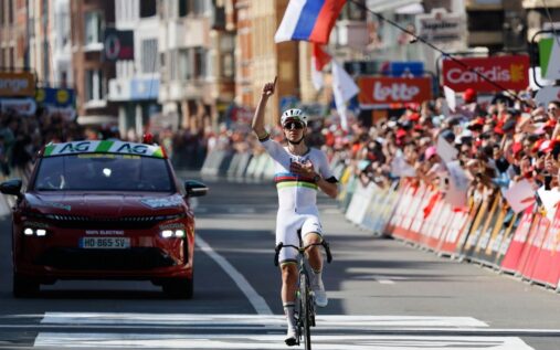 Tadej Pogacar pointing to the sky while crossing the finish line at Liege-Bastogne-Liege to honour a late teammate.