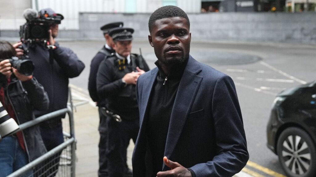 Thomas Partey wearing a dark grey suit and black jumper arriving at Southwark Crown Court