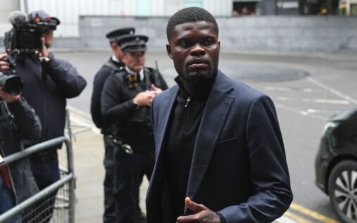Thomas Partey wearing a dark grey suit and black jumper arriving at Southwark Crown Court