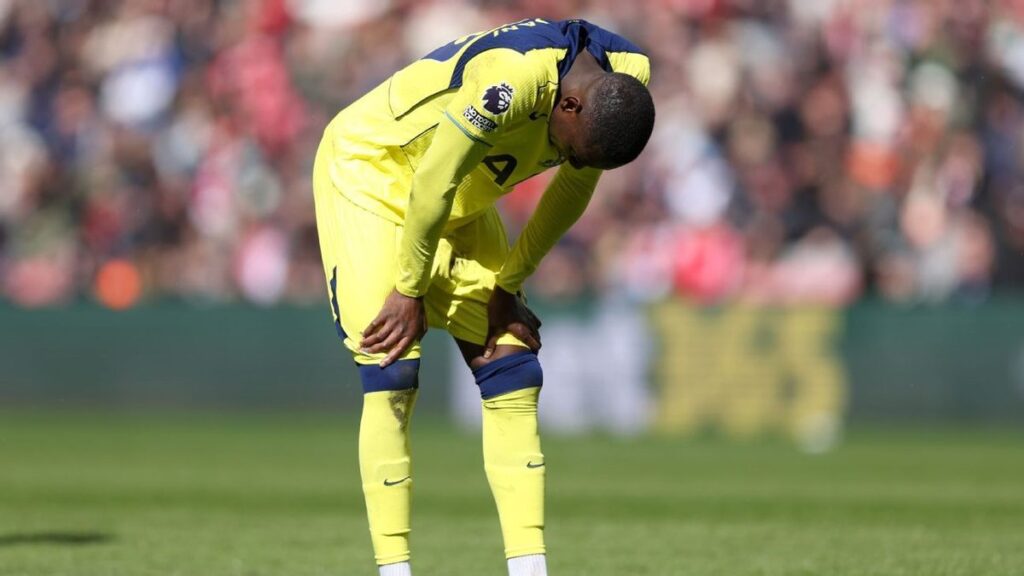 Dejected Tottenham Hotspur players standing on the pitch during a Premier League match