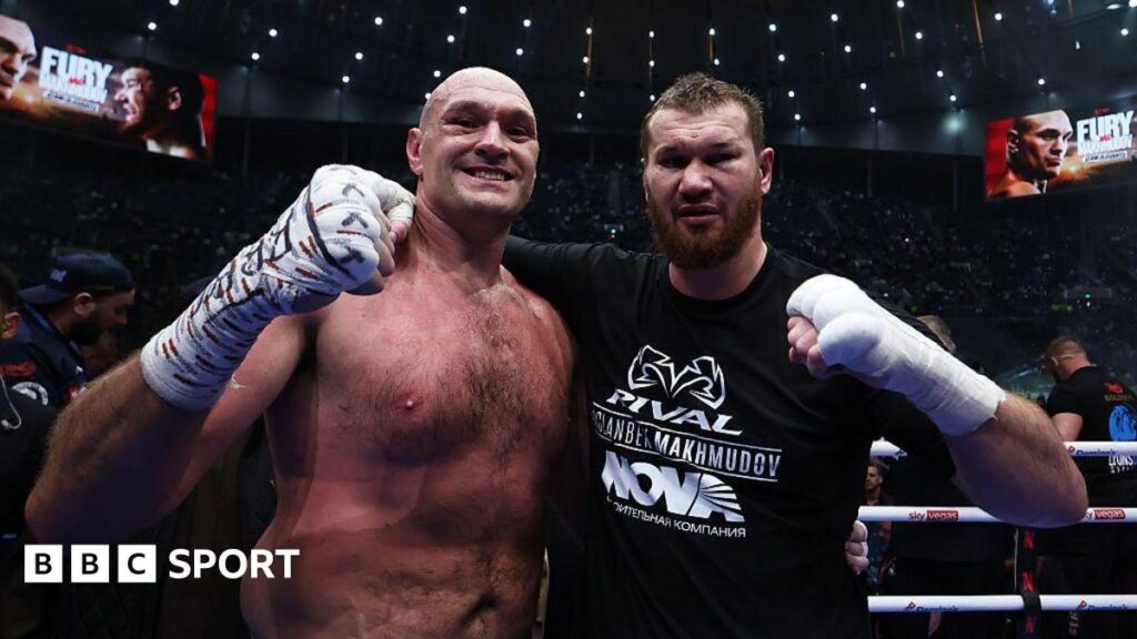 Tyson Fury standing victorious in the boxing ring after defeating Arslanbek Makhmudov