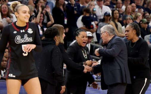 UConn head coach Geno Auriemma looking visibly frustrated on the touchline during a basketball match.