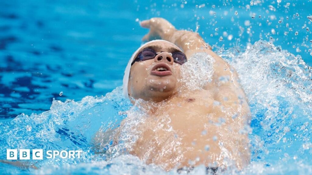 A competitive swimmer diving into a pool at a World Aquatics event
