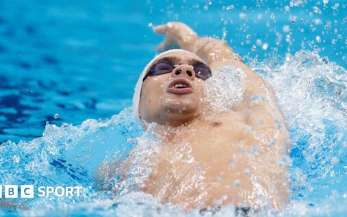 A competitive swimmer diving into a pool at a World Aquatics event