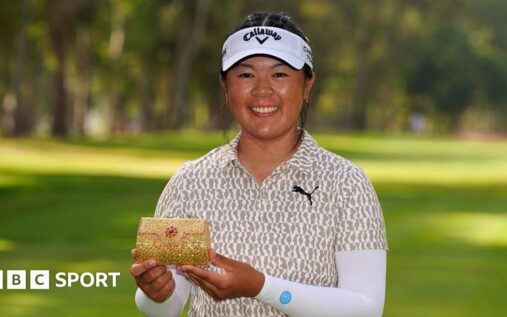 Anna Huang smiling and holding the Lalla Meryem Cup trophy on the golf course in Morocco