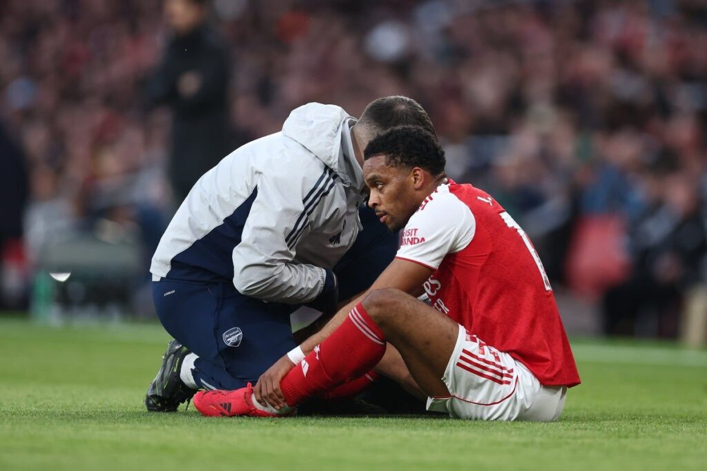 Jurrien Timber walking on the pitch looking dejected in an Arsenal shirt