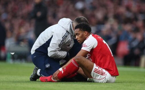 Jurrien Timber walking on the pitch looking dejected in an Arsenal shirt