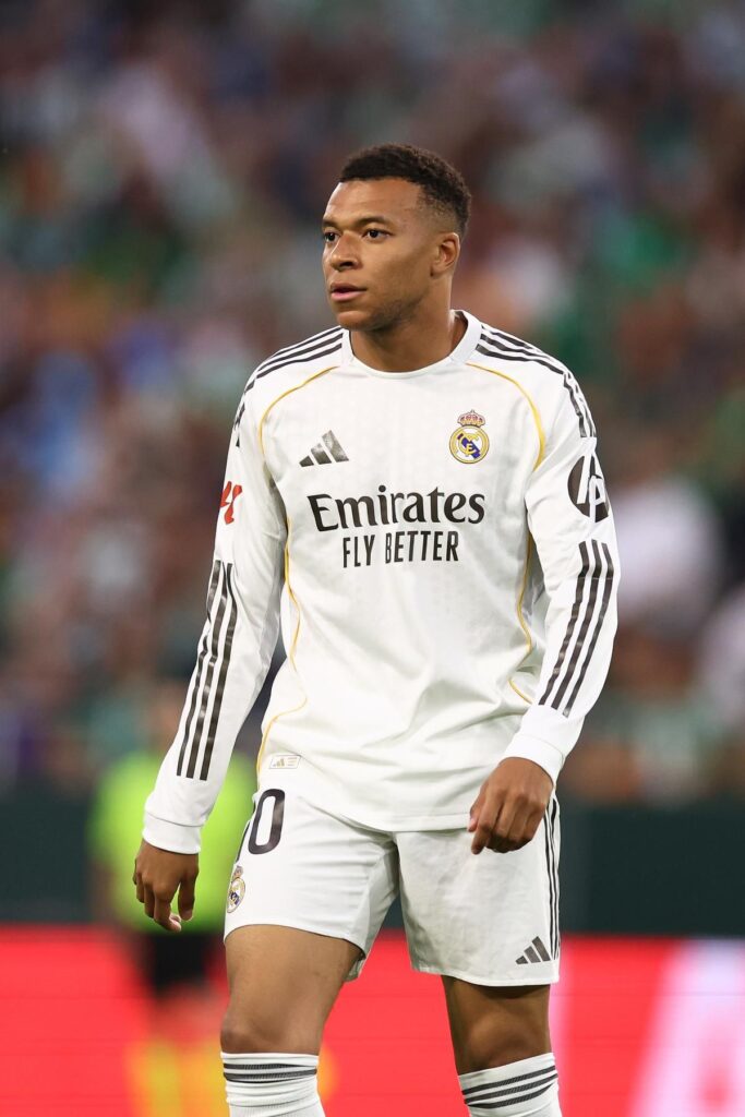 Kylian Mbappe looking thoughtful on the pitch wearing a Real Madrid kit