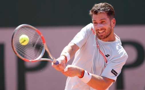 Cameron Norrie walking off a clay court looking dejected after retiring from the French Open