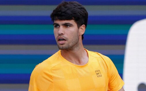 Carlos Alcaraz looking dejected on a tennis court holding his tennis racket