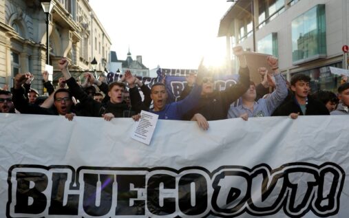 Chelsea supporters holding protest banners against BlueCo ownership outside a football stadium