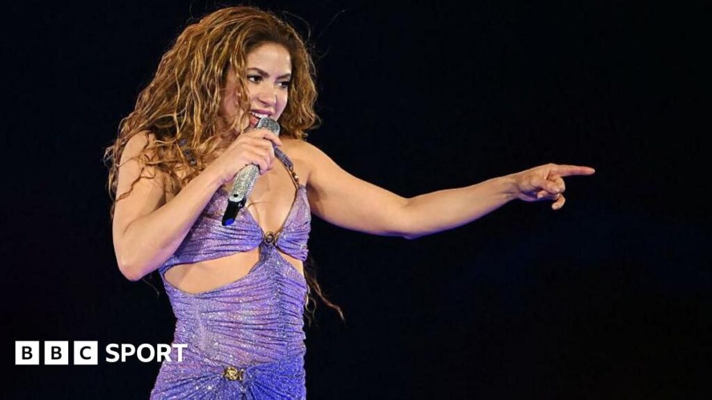 Shakira performing on stage during a live stadium concert