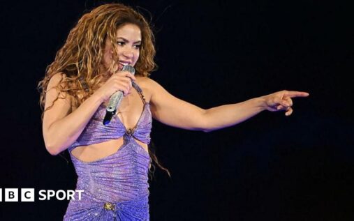 Shakira performing on stage during a live stadium concert
