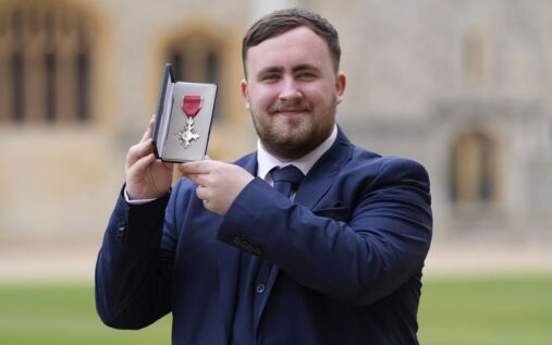 Luke Littler smiling as he is presented with his MBE medal by Prince William at Windsor