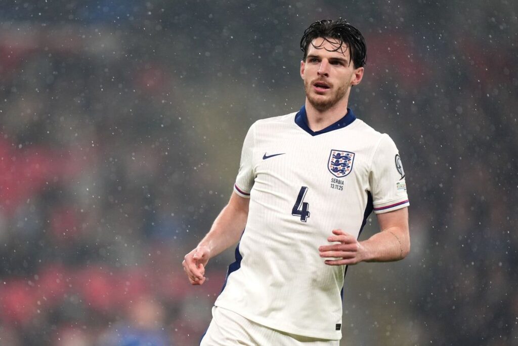 Declan Rice wearing an England national team football shirt looking focused on the pitch