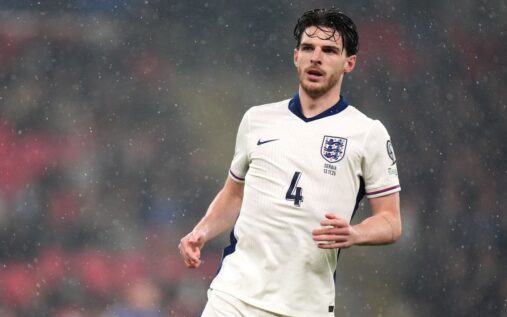 Declan Rice wearing an England national team football shirt looking focused on the pitch