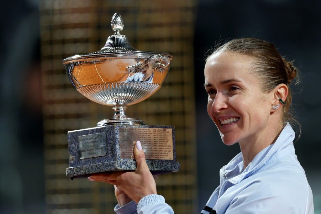 Elina Svitolina and Marta Kostyuk holding their respective WTA tennis championship trophies