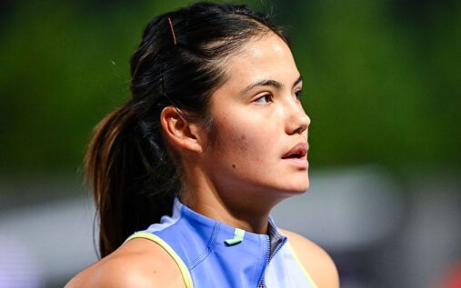 Emma Raducanu holding her tennis racket and looking disappointed on a clay court