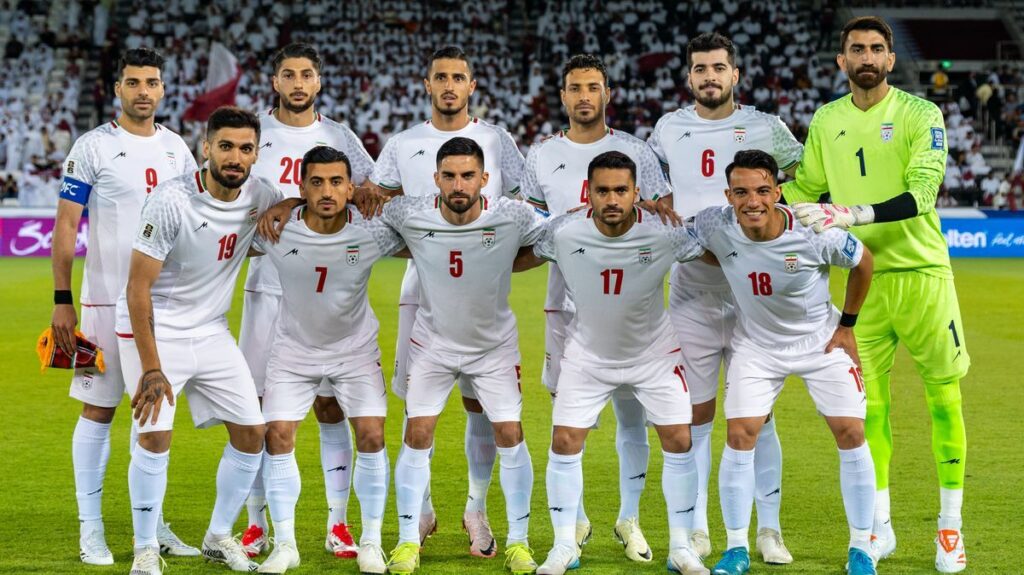 Iran national football team players lining up on the pitch before a match