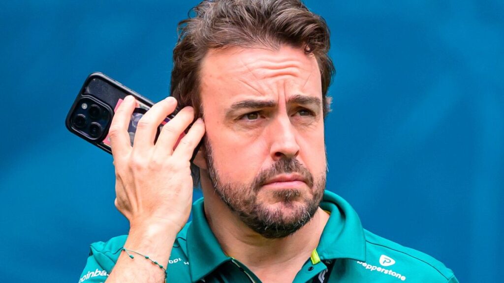 Fernando Alonso wearing his green Aston Martin racing overalls in the Formula 1 paddock