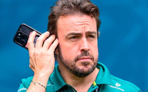 Fernando Alonso wearing his green Aston Martin racing overalls in the Formula 1 paddock