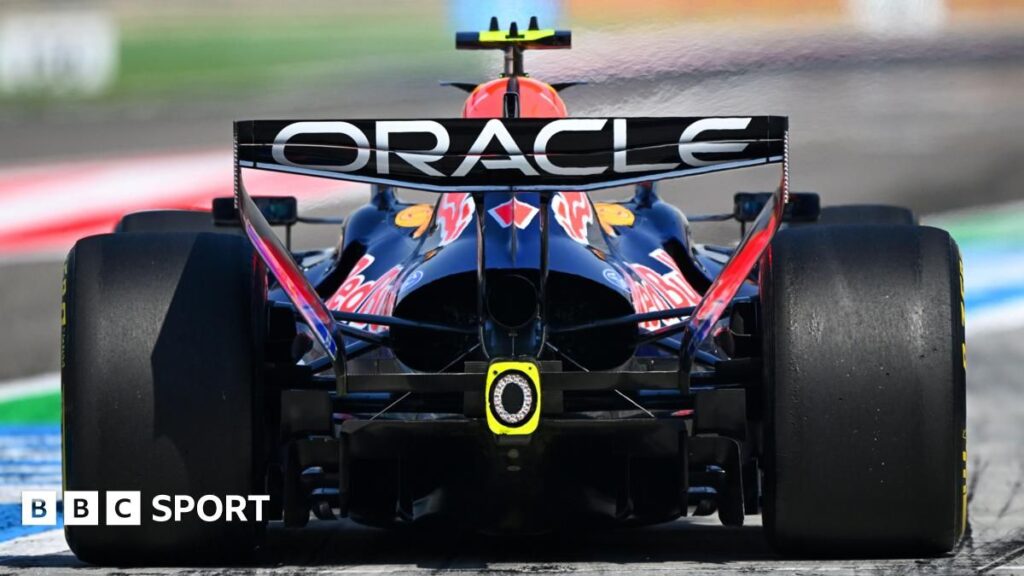Formula 1 cars racing on track with a focus on the rear engine and exhaust area