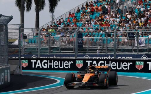 Formula 1 cars racing on a wet track under stormy skies at the Miami Grand Prix