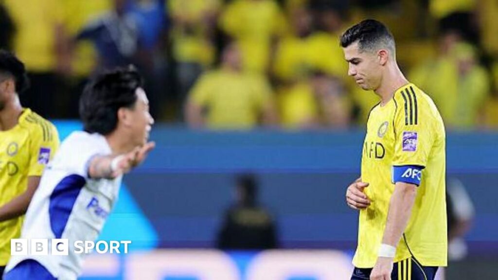 Cristiano Ronaldo looking dejected on the pitch wearing the yellow Al-Nassr kit