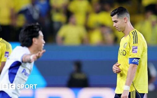 Cristiano Ronaldo looking dejected on the pitch wearing the yellow Al-Nassr kit