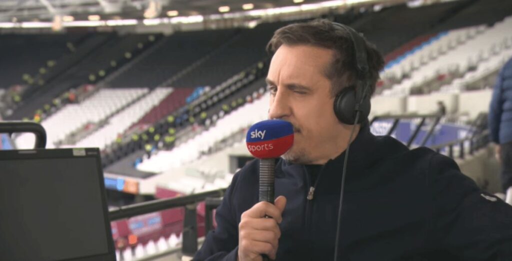 Gary Neville speaking into a broadcasting microphone while analysing a football match