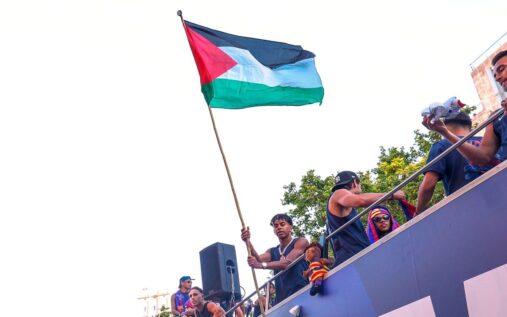 Barcelona winger Lamine Yamal waving a Palestinian flag from an open-top bus