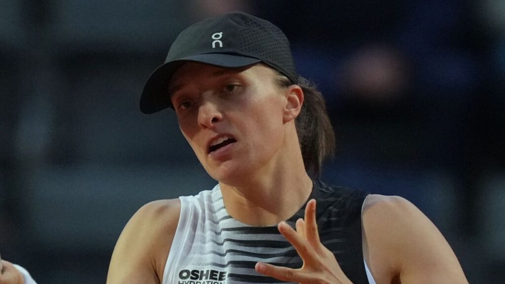 Iga Swiatek striking a powerful forehand during her Italian Open match on the clay courts in Rome