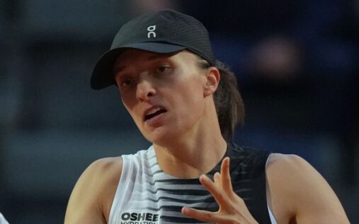 Iga Swiatek striking a powerful forehand during her Italian Open match on the clay courts in Rome