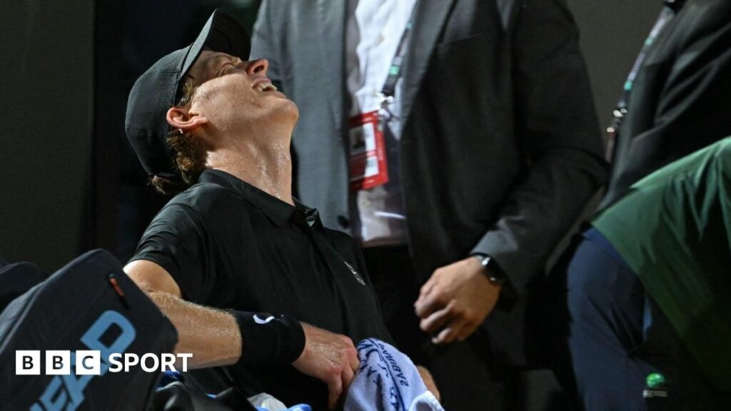 Jannik Sinner leaning on his tennis racquet during the Italian Open semi-final against Daniil Medvedev