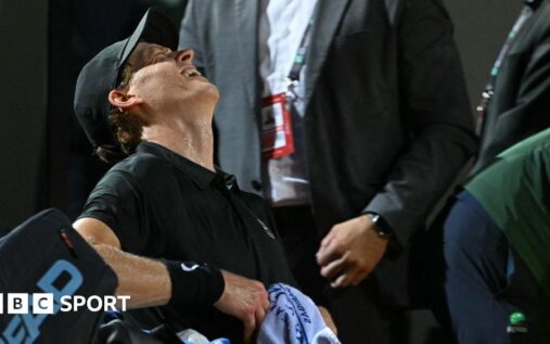 Jannik Sinner leaning on his tennis racquet during the Italian Open semi-final against Daniil Medvedev