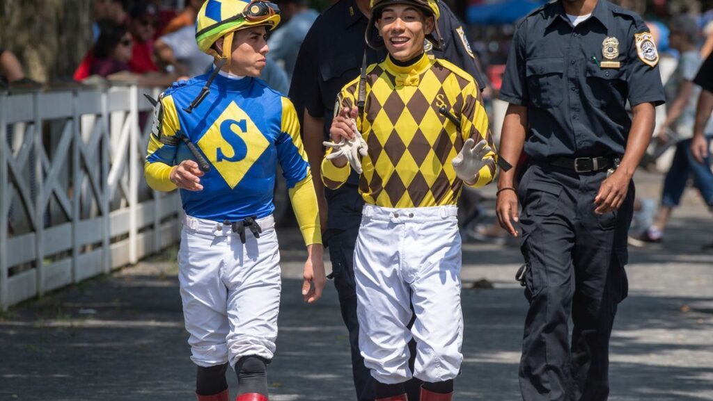 Jockeys Jose and Irad Ortiz riding racehorses on the dirt track