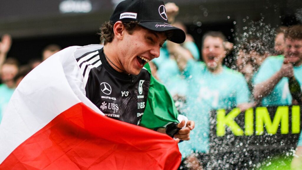 Mercedes Formula 1 driver Kimi Antonelli wearing his race suit and helmet while celebrating a grand prix victory