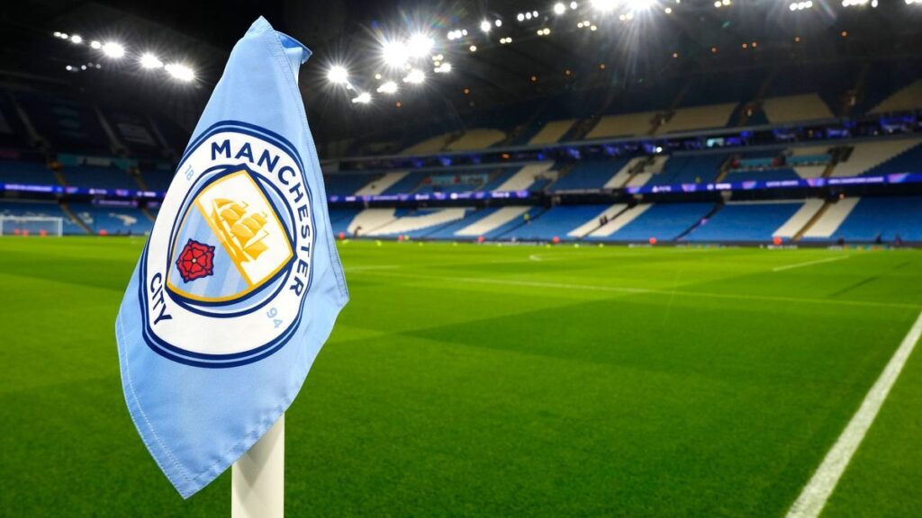 Manchester City manager Pep Guardiola standing thoughtfully on the touchline during a Premier League match