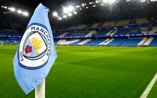 Manchester City manager Pep Guardiola standing thoughtfully on the touchline during a Premier League match