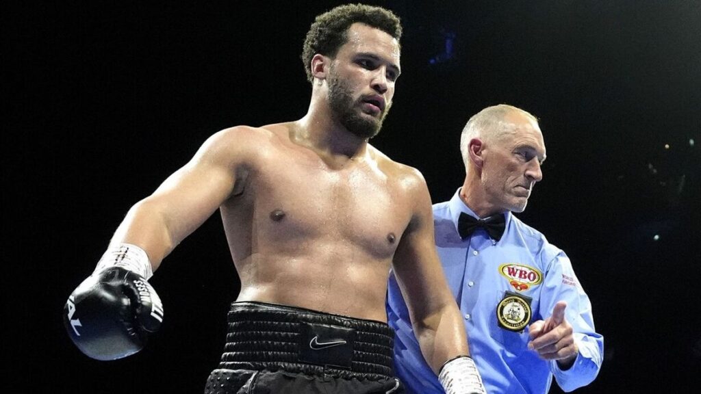 Moses Itauma posing with boxing gloves inside the ring