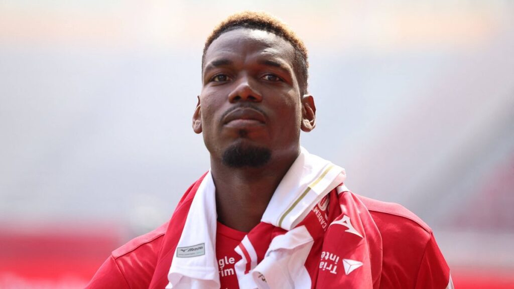 Paul Pogba looking dejected while sitting on the pitch in a Monaco shirt
