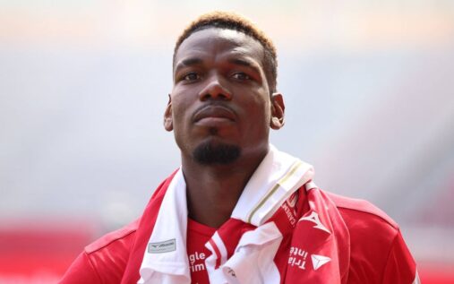 Paul Pogba looking dejected while sitting on the pitch in a Monaco shirt