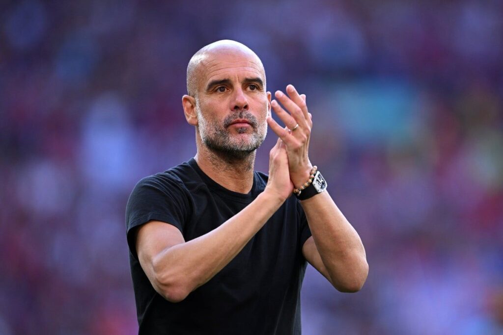 Manchester City manager Pep Guardiola standing on the touchline looking thoughtful