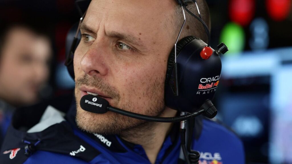Gianpiero Lambiase wearing a Red Bull racing headset looking thoughtfully at a monitor in the Formula 1 paddock