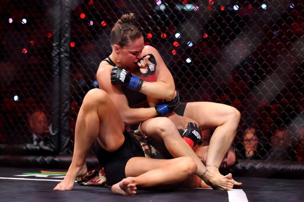 Ronda Rousey and Gina Carano facing off inside the MMA cage