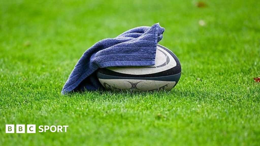 A rugby union player receiving medical attention for a head injury on the pitch