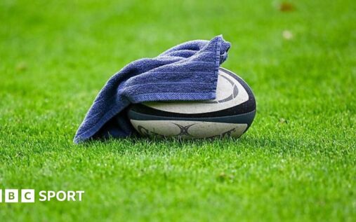 A rugby union player receiving medical attention for a head injury on the pitch